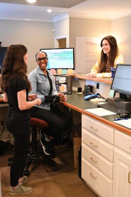 Patient Chatting With Reception Staff At Combs Chiropractic & Wellness