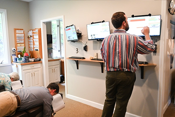 Chiropractor Alex Combs With Patients In Adjustment Room